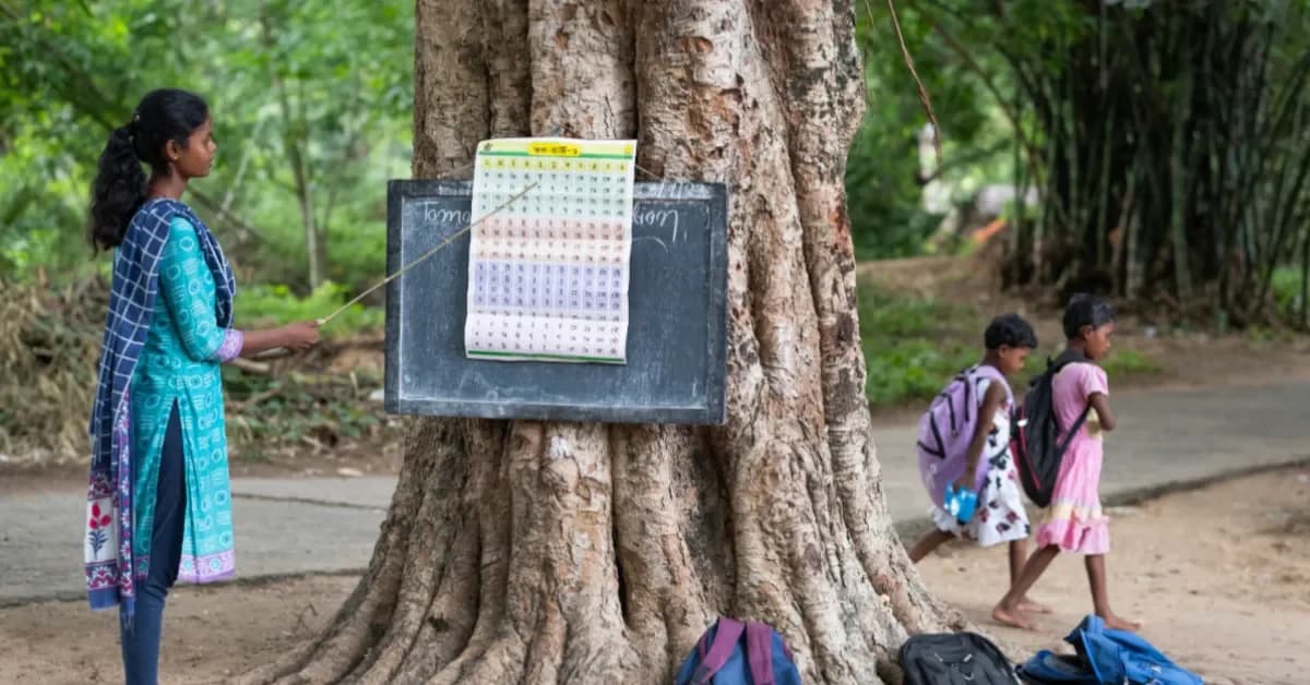 Docente señala una lámina colocada junto a un pizarrón al aire libre