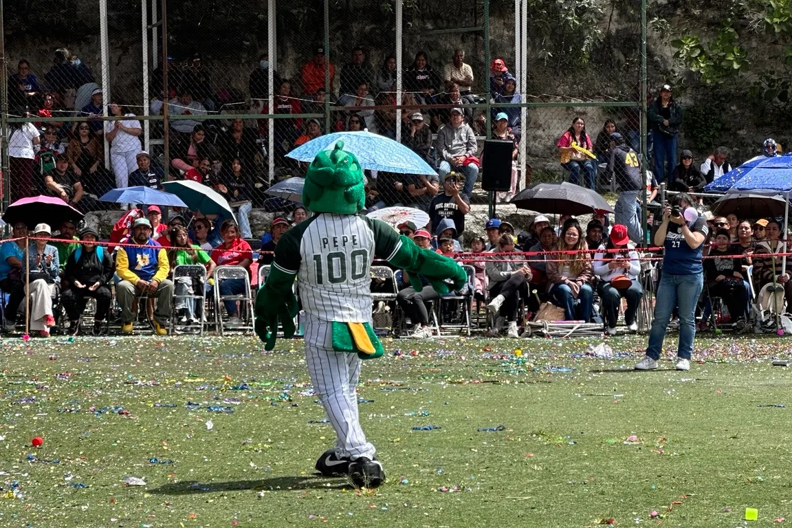 Una mascota de béisbol frente a las gradas con público.